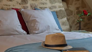 Una cama con un sombrero de paja y un libro encima.