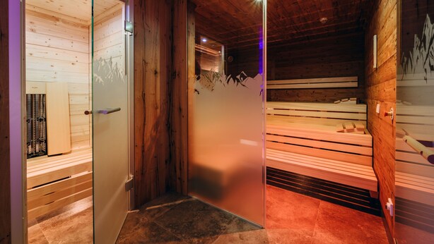 Un interior de madera con un ventanal que da a una zona de sauna.