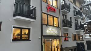 Un hotel con balcones, un cartel que dice 'Grieswiin Hotel & Restaurant' y una escalera que lleva a la entrada.