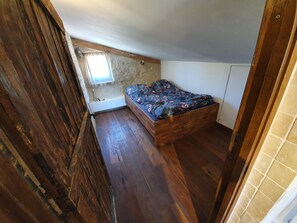 Cozy retreat with a bed, wooden bench, and natural light.