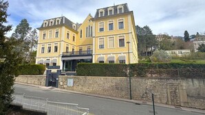 Ein großes, gelbes Gebäude mit einer Steinmauer und einem ehrfurchtgebietenden Eingangstor.