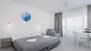 Una habitación de hotel moderna con una cama grande, un escritorio y una silla.