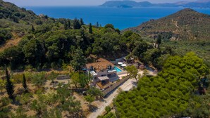 An aerial view of a villa with a swimming pool, surrounded by dense greenery and overlooking a coastal area. - Andromeda Luxury Villa (Zakynthos)