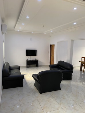 Relax in the open-plan living area with a flat-screen TV, comfortable seating, and a convenient side table.