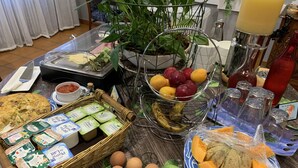 A breakfast buffet with various food items, including eggs, cheese, fruits, and beverages. - L'Embleme Boutique Hotel (Beaurepaire)