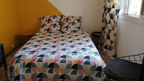 A bedroom with a bed, a chair, a TV, and a window with curtains. - The Cabanon from the Pas du Loup (la seyne sur mer)