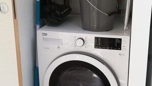 A compact laundry area with a front-loading washing machine, a drying machine, and a vacuum cleaner. - The Cabanon from the Pas du Loup (la seyne sur mer)