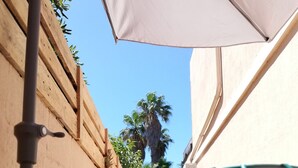 An outdoor seating area with a table, chairs, and a table lamp. - The Cabanon from the Pas du Loup (la seyne sur mer)