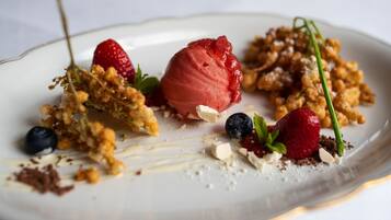 Un plato de postre con diversas frutas y una bola de helado.
