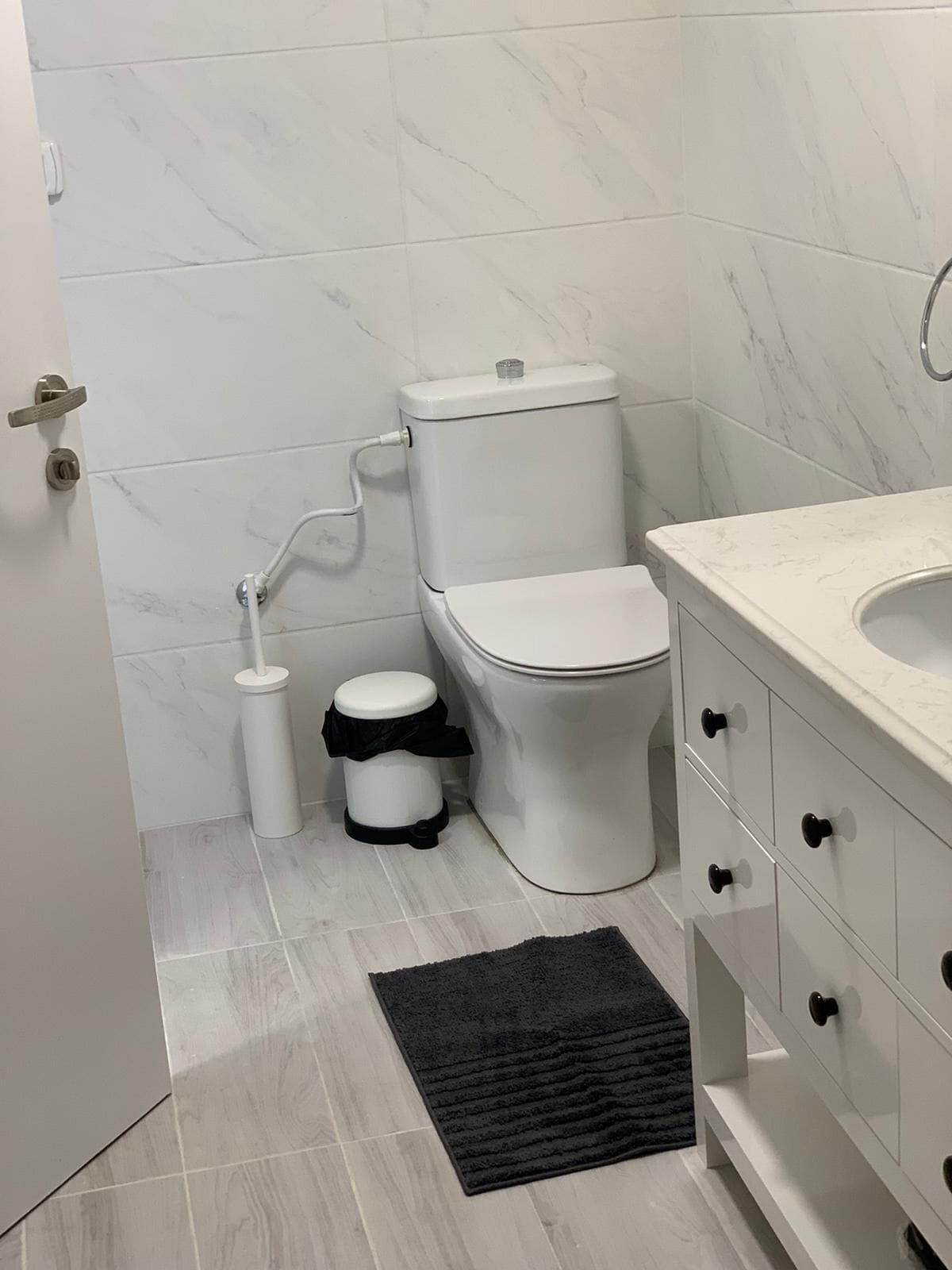 Un bany amb vàter, bidet i un moble de bany blanc amb calaixos.