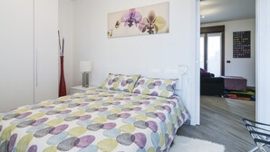 A bedroom with a bed, a nightstand, a lamp, and a wall art piece. - North Milan - Close to metro - Wi-Fi (Milano)