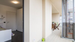 A corridor with a bed, a door, and a view of a balcony with a railing. - North Milan - Close to metro - Wi-Fi (Milano)