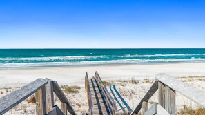 A wooden staircase leading to a sandy beach with a view of the ocean. - Dune Our Thing: Charming North Cape Home- Sleeps 14, New Private Pool! (Cape San Blas)