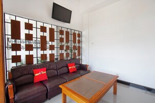 Una sala moderna con un sofá de cuero, una mesa de centro de madera y un panel decorativo en la pared.