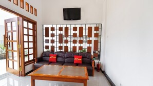 A modern living room with a sofa, a wooden coffee table, and a decorative wall panel.