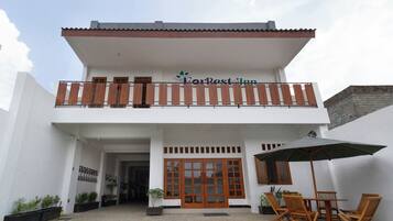 A two-story building with a balcony and a sign that reads "ForBest Inn".