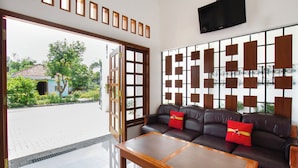 A modern living room with a sofa, a coffee table, and a decorative wall panel.