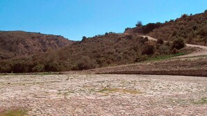 Une zone pavée avec un sentier de terre qui monte la colline.