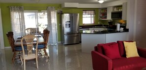 Compact living space with a kitchenette and dining area, featuring a refrigerator, microwave, and sink.