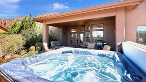 A hot tub in a covered outdoor area with seating and a grill. - Experience luxury at Sedona Star View, a 3-bed home with stunning red rock views. (Sedona)