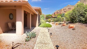 A building with a patio area, outdoor seating, and a garden with desert plants. - Experience luxury at Sedona Star View, a 3-bed home with stunning red rock views. (Sedona)