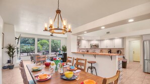 A spacious kitchen with a dining area, large windows, and a chandelier. - Experience luxury at Sedona Star View, a 3-bed home with stunning red rock views. (Sedona)