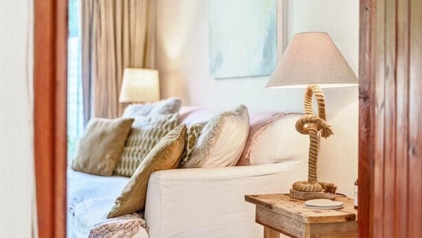 A cozy bedroom with a bed, a bedside table with a lamp, and a window with curtains. - Apple Cottage - Central Frome - Family Friendly (Somerset)