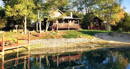 1800’s restored log cabin on 26 private rolling wooded acres with sunset views