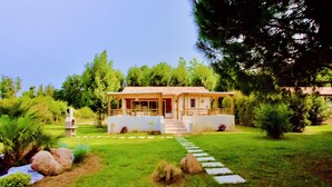 A house with a red-tiled roof, a covered porch, and a stone pathway leading to the entrance. - Campo Vecchio Mare & Piscine (Ghisonaccia)
