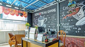 A reception desk with a chalkboard wall, a coffee machine, and a sign reading 'Receptionist'. - OYO 3214 Puri Amalia (Banyuwangi)