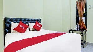 A hotel room with a bed, a black headboard, and a red and white bedspread. - OYO 3214 Puri Amalia (Banyuwangi)