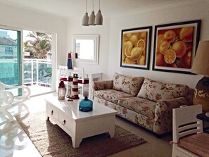 Relax in this stylish living room with a sofa, coffee table, and beautiful views of palm trees.