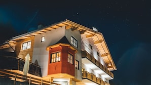 Un hotel de varios pisos con un llamativo letrero que dice 'HOTEL', un balcón en el piso superior y una fachada bien iluminada.