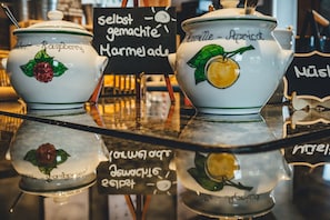 Two ceramic pots with fruit designs on a reflective surface. - Hotel Sportalm (Bad Kleinkirchheim)