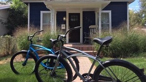 Een huis met een veranda en twee fietsen ervoor geparkeerd.