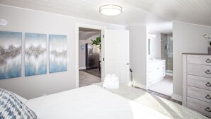 A bedroom with a bed, a dresser, and a door leading to a bathroom. - Couple’s Getaway | Walk to UNC |FREE Cruiser Bikes (Greeley)
