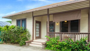 A single-story house with a front porch, a door, and a small set of steps leading to the entrance.