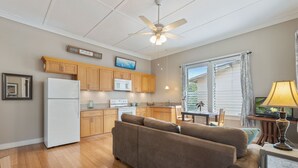 A modern kitchen with wooden cabinets, a white refrigerator, and a ceiling fan.