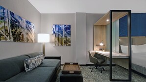 A hotel room with a sofa, a desk, a chair, a bedside table, and a bed. - SpringHill Suites by Marriott Franklin Cool Springs (Franklin)