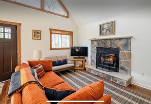 Smart TV, chimenea, libros y biblioteca musical 