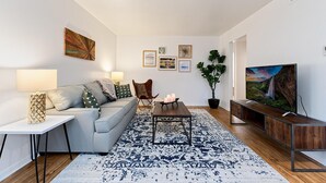 Una sala de estar moderna con sofá, mesa de centro y televisor.