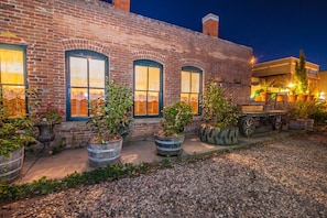 A brick building with large windows and potted plants.