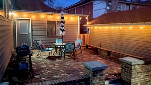 A patio with brick flooring, a table, and chairs. - Gorgeous Guest Suite. Walk to Old Town & CSU! (Fort Collins)