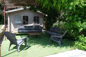 A patio with a sofa, chairs, and a table.