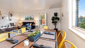 A modern living room with a dining area, featuring a sofa, chairs, a table, and a potted plant. - Hidden Gem Near Old Town, BBQ & Bikes!! (Fort Collins)