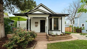 A house with a front porch, a mailbox, and a well-maintained garden. - Lola House! Cozy comfort, Prime Old Town Location (Fort Collins)