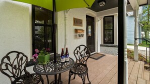 A covered patio with a table and chairs, a green umbrella, and a mailbox with the number 522. - Lola House! Cozy comfort, Prime Old Town Location (Fort Collins)
