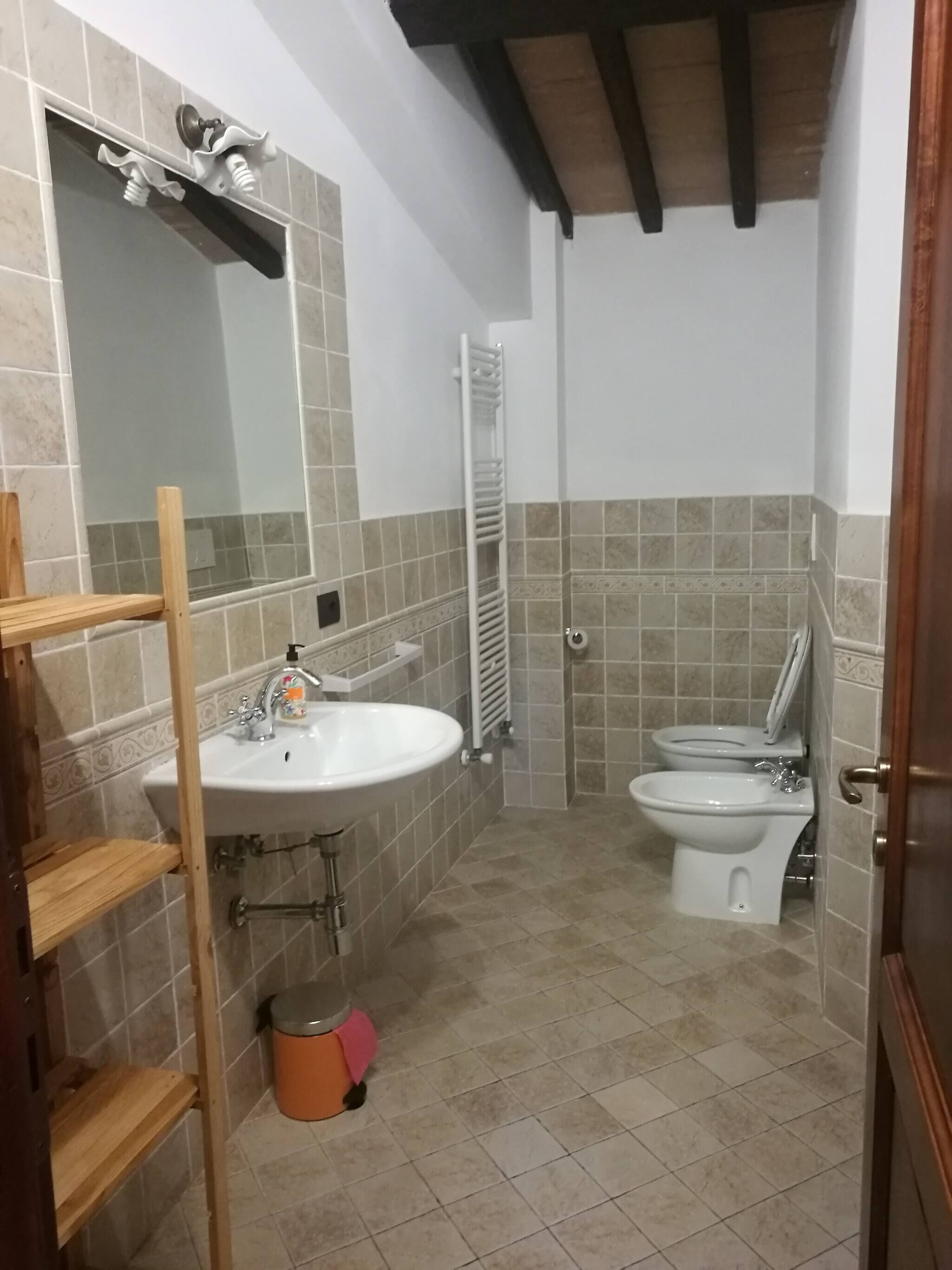 Un bagno con lavandino, specchio, toilette e doccia.
