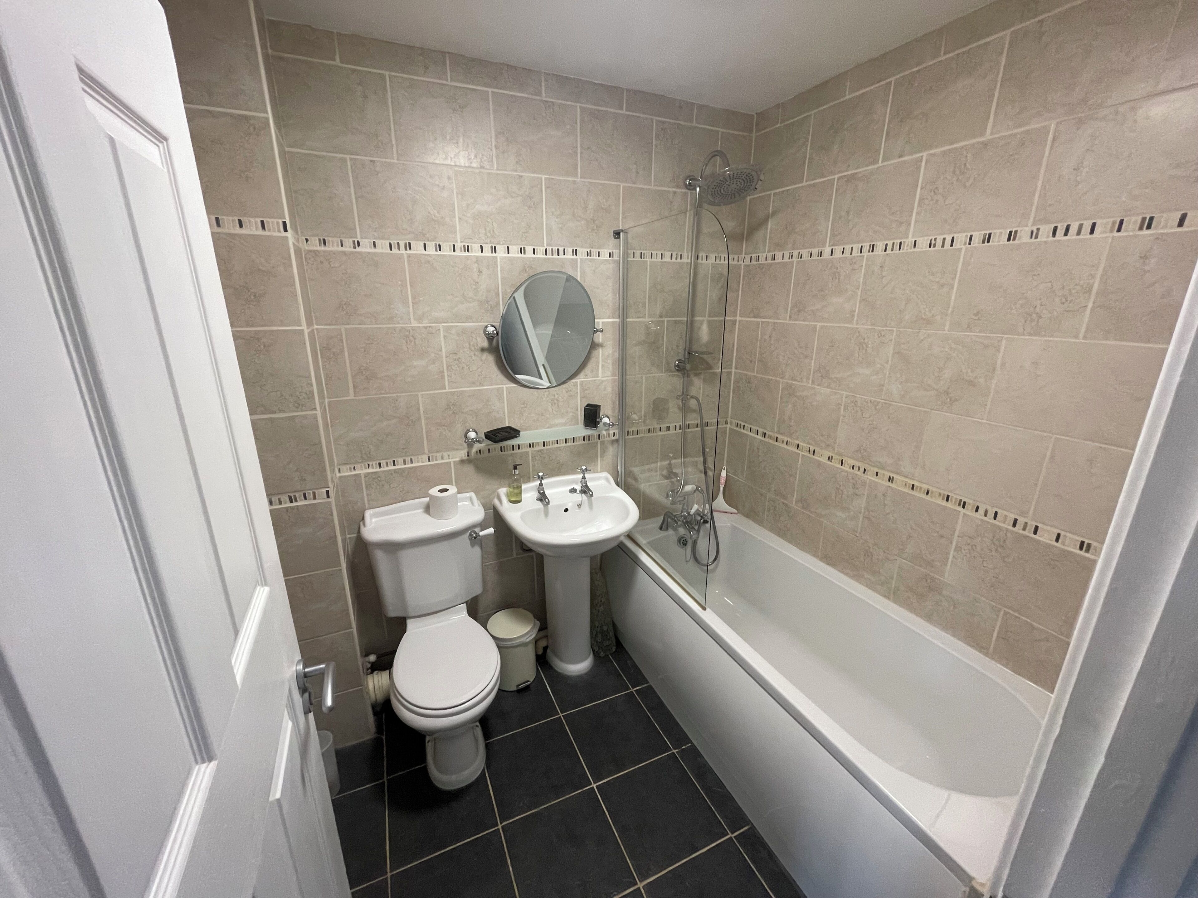 A bathroom with a toilet, sink, and shower.