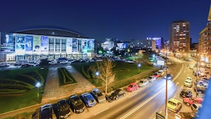 A nighttime view of a cityscape with a large illuminated building, a parking lot with cars, and surrounding urban buildings. - Elegance Studio - Cismigiu Gardens - Free Wifi - Panoramic View (Bucharest)